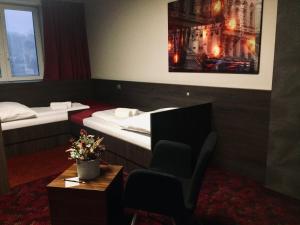 una habitación de hotel con 2 camas y una silla en Kongres Hotel Roca, en Košice