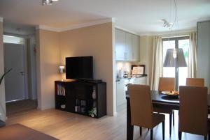 cocina y comedor con mesa y TV en Luxuswohnung Abendsonne, en Wenningstedt