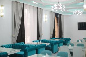 a conference room with blue chairs and tables and a chandelier at Reikartz Amirun Tashkent in Tashkent