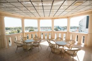 a large room with tables and chairs on a balcony at Reikartz Amirun Tashkent in Tashkent