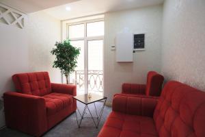 a waiting room with two red chairs and a table at Reikartz Amirun Tashkent in Tashkent