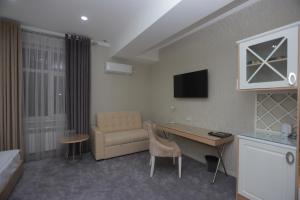 a hotel room with a couch and a table and a desk at Reikartz Amirun Tashkent in Tashkent