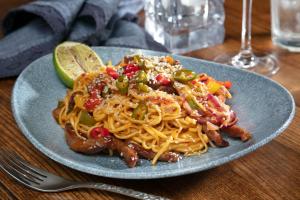 a plate of food with noodles and a lime at The Bold Hotel; BW Signature Collection in Southport