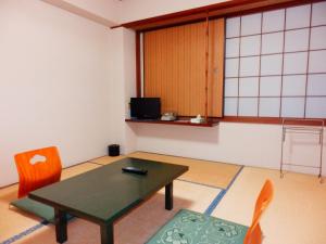 un soggiorno con tavolo e sedie di Nakayasu Ryokan a Kanazawa