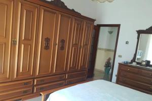 een slaapkamer met een grote houten kast en een bed bij Napoli Pompei Sorrento Appartamento con Posto Auto in Gragnano