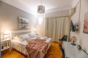 Schlafzimmer mit einem Bett, einem Schreibtisch und einem Stuhl in der Unterkunft Erato by Heloni Apartments in Athen