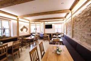 a restaurant with wooden tables and chairs and a brick wall at Spirklhof in Bodenkirchen