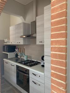cocina con armarios blancos y fogones en Casina Summer en Tirrenia