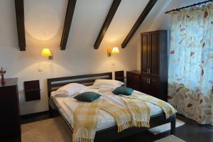 una camera da letto con un letto con lenzuola bianche e cuscini verdi di Trout Cottage 2 a Predeluţ