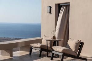 a room with a table and two chairs and a window at Nimbus Santorini in Oia