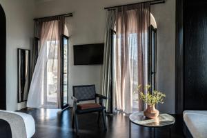 1 dormitorio con 1 cama, 1 silla y 1 mesa en Nimbus Santorini, en Oia