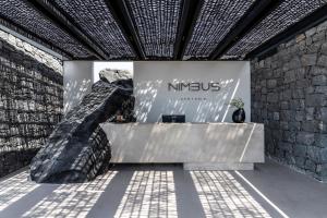 a lobby of a nitschkouseum with a stone wall at Nimbus Santorini in Oia