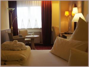 Habitación de hotel con cama, mesa y ventana en Sletz Parkhotel - Superior, en Giessen