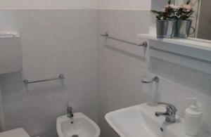 bagno bianco con lavandino e servizi igienici di Twin room Merida a Gela