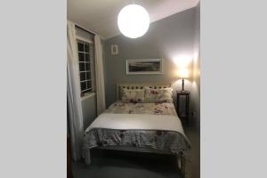 a bedroom with a bed and a lamp at Newlands East, Durban Home, Panoramic•Peaceful• in Duffʼs Road