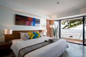 a bedroom with a bed with a view of the ocean at Sunset Beach Resort - SHA Extra Plus in Patong Beach