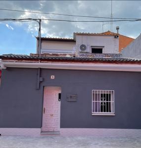 een blauw gebouw met een deur en een raam bij Casita tranquila in Talavera de la Reina