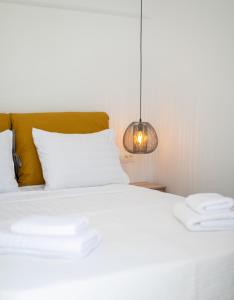 a bedroom with a white bed and a lamp at Mytheo in Mýkonos City