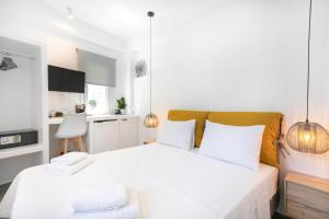 1 dormitorio con 1 cama blanca grande con almohadas blancas en Mytheo, en Mykonos ciudad