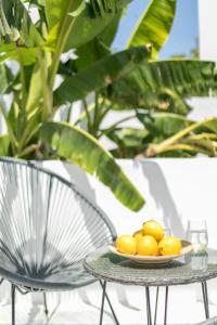 a plate of lemons on a table next to a chair at Mytheo in Mýkonos City
