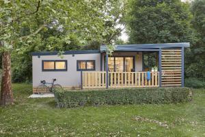 domek na podwórku z drzewem w obiekcie Donaupark Camping Tulln w mieście Tulln