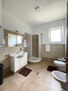 a bathroom with a shower and two sinks and a toilet at Apartman Nikolic,Banja Vrucica,Teslic in Teslić