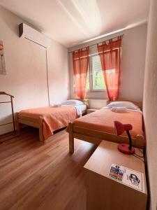 テスリチにあるApartman Nikolic,Banja Vrucica,Teslicのベッド2台とテーブルが備わる小さな客室です。