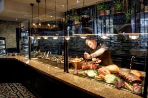 a chef preparing food behind a counter in a restaurant at The Bold Hotel; BW Signature Collection in Southport