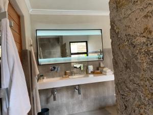 a bathroom with a sink and a large mirror at African Rock Hotel and Spa in Kempton Park