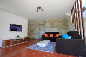 uma sala de estar com dois sofás e uma parede de pedra em Quinta Miranda em Geraz do Lima
