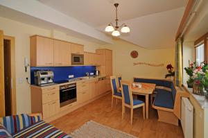 eine Küche und ein Esszimmer mit einem Tisch und Stühlen in der Unterkunft Appartement Alpenblume in Schladming