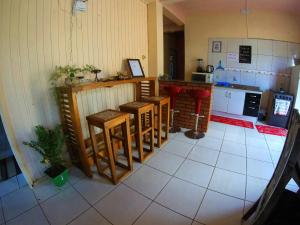 a kitchen with tables and a counter in a room at Itaimbezinho Hostel Santa Catarina in Praia Grande