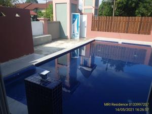 a swimming pool with blue water in a house at MRI Residence - Homestay in Sg Buloh with Swimming Pool - No Pork&Alcohol Allowed in Bandar Puncak Alam