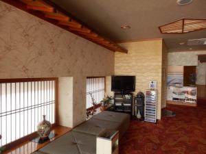 a living room with a couch and a flat screen tv at Hanagoyomi in Nanao