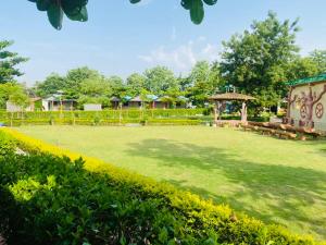 a large yard with benches and a gazebo at Lighthouse Waterpark and Resort in Mansar