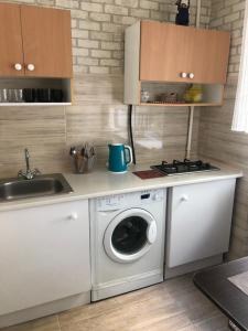 uma cozinha com uma máquina de lavar roupa e um lavatório em Kyiv Apartment in Pechersk on Oleksandra Kopylenko em Kiev