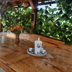 a table with a bottle and two cups on it at Holiday Apartman Ravna Dolina in Cetingrad