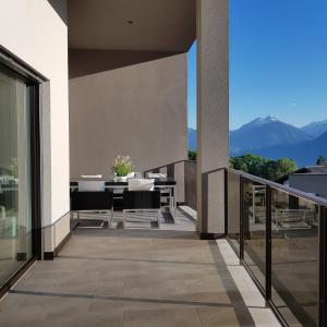 a balcony with a table and chairs and mountains at Rooftop-Schenna in Schenna