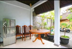 einen Tisch und Stühle auf einer Terrasse mit einem Kühlschrank in der Unterkunft Ibus room canggu By SDM in Canggu