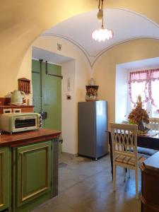 a kitchen with a refrigerator and a table with a chair at La Foresteria del Passeggere in Ovada