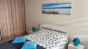 sypialnia z łóżkiem z niebieskimi poduszkami w obiekcie Apartament Morski Lazurowy Gdynia w mieście Gdynia