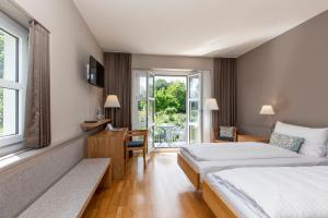 um quarto de hotel com duas camas e uma janela em See & Park Hotel Feldbach em Steckborn
