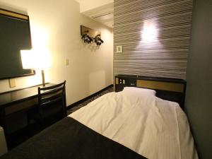 1 dormitorio con cama, lámpara y ventana en APA Hotel Komatsu Grand en Komatsu