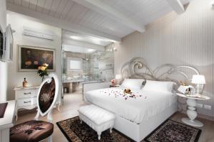 a bedroom with a white bed and a bathroom at Princier Fine Resort & SPA in Rimini