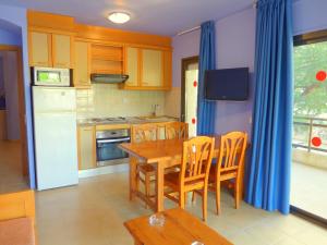 a kitchen with a table and chairs and a kitchen with a refrigerator at Rentalmar Diplomatic Park in Salou