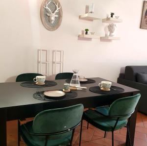 einem schwarzen Tisch mit grünen Stühlen und einer Uhr an der Wand in der Unterkunft Loft 5c - Palatino in Rom