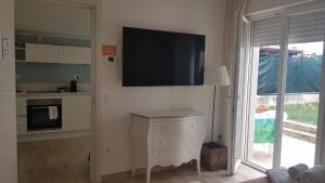 a living room with a tv on the wall at Gli Oleandri in Porto San Giorgio
