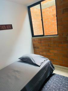 Bett in einem Zimmer mit Ziegelwand in der Unterkunft Casa Roma - La tranquilidad del campo en la Ciudad - RNT 1 0 8 1 3 7- in Salento