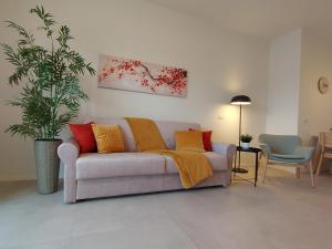 uma sala de estar com um sofá com almofadas coloridas em Suite Rent Milan 3 em Milão