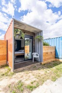 a tiny house with a bedroom and a fence at Trois Six Vendée in Toulon-sur-Arroux